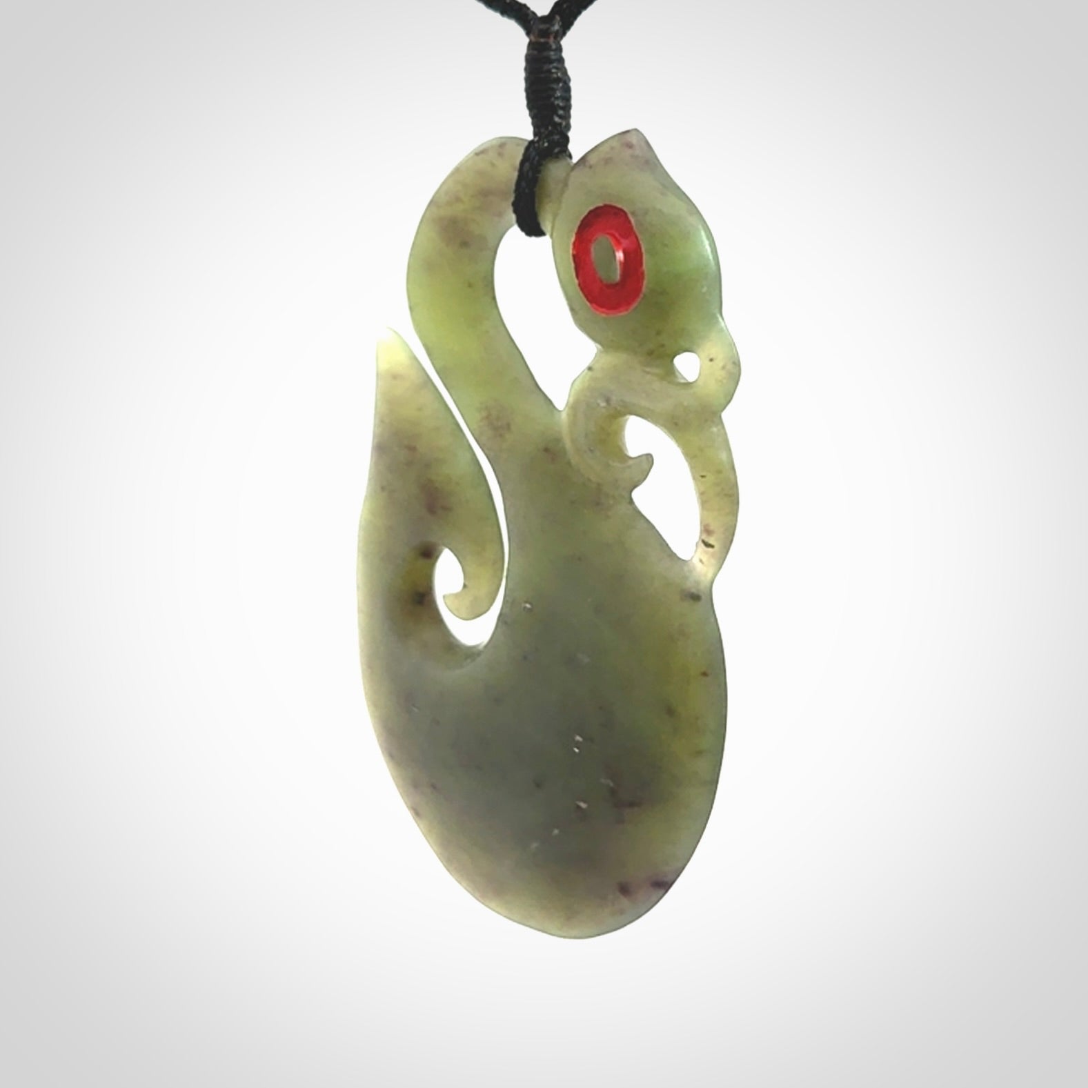 This picture shows a traditional manaia with hook pendant carved in New Zealand Jade.