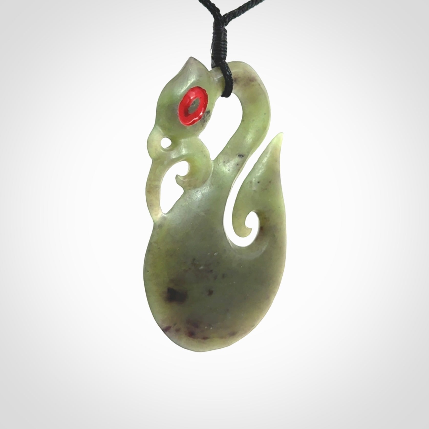 This picture shows a traditional manaia with hook pendant carved in New Zealand Jade.