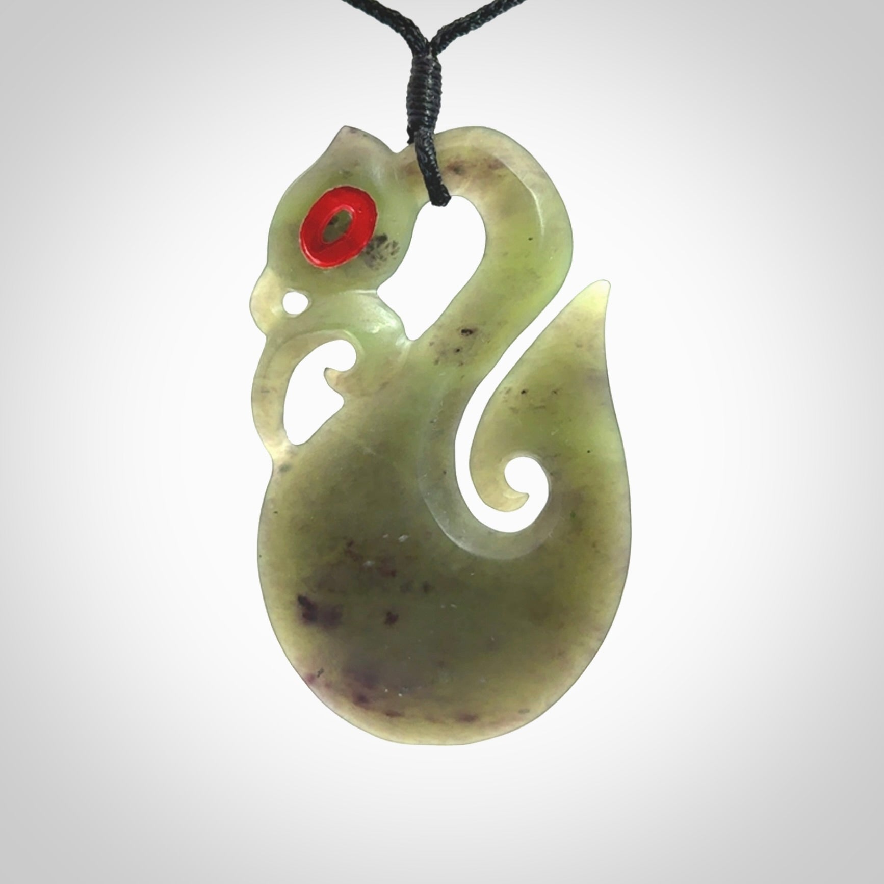 This picture shows a traditional manaia with hook pendant carved in New Zealand Jade.