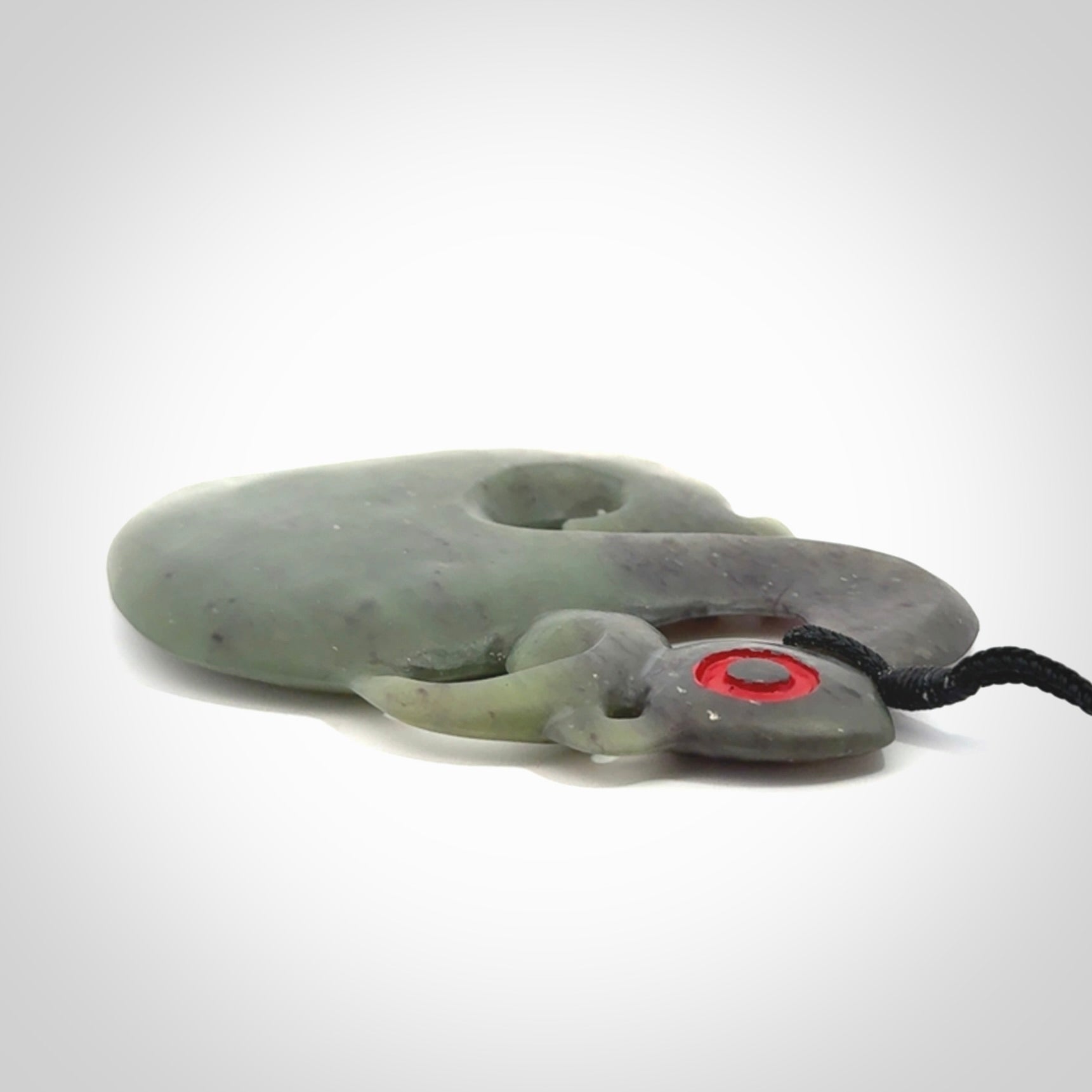 This picture shows a large traditional manaia pendant carved in New Zealand Jade.