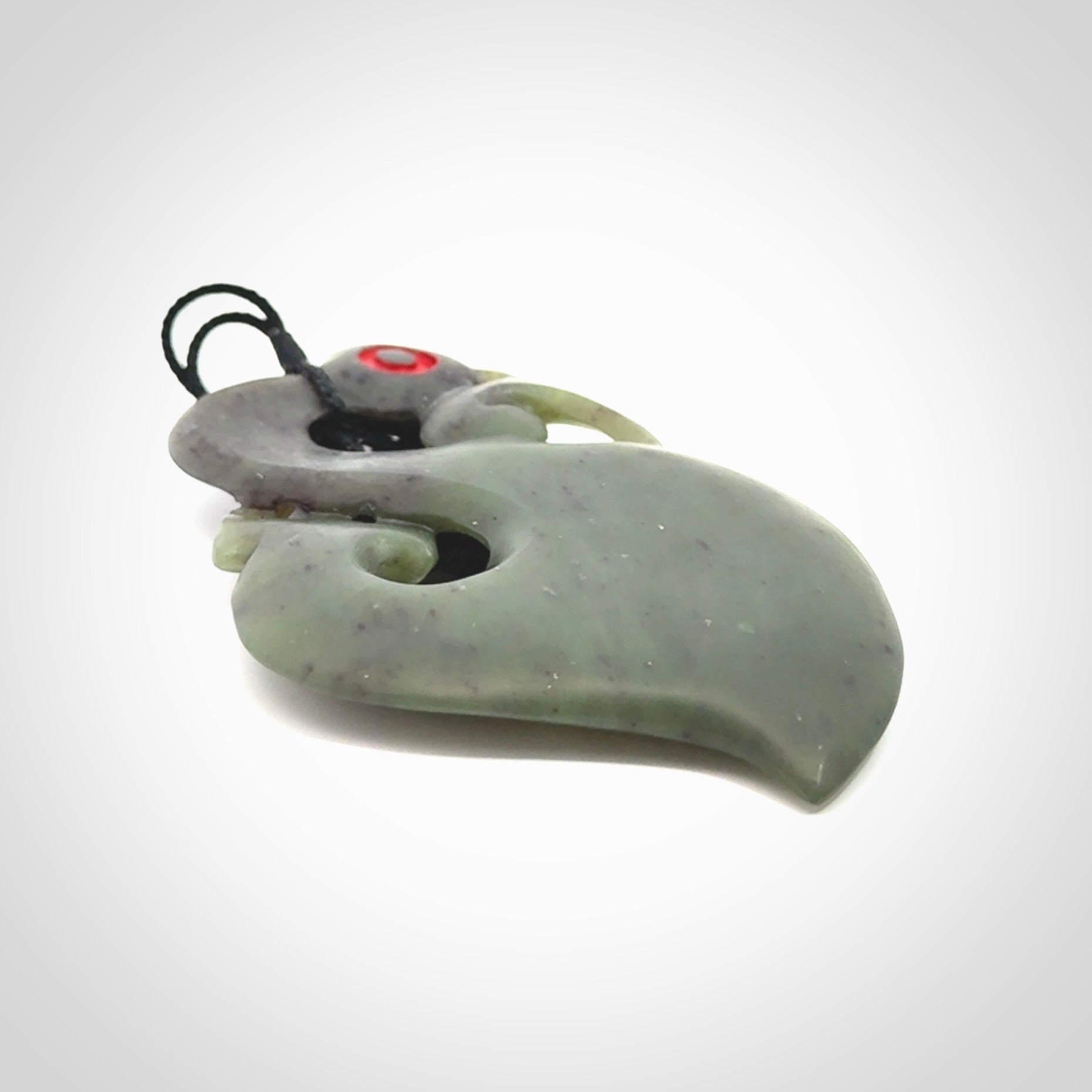 This picture shows a large traditional manaia pendant carved in New Zealand Jade.
