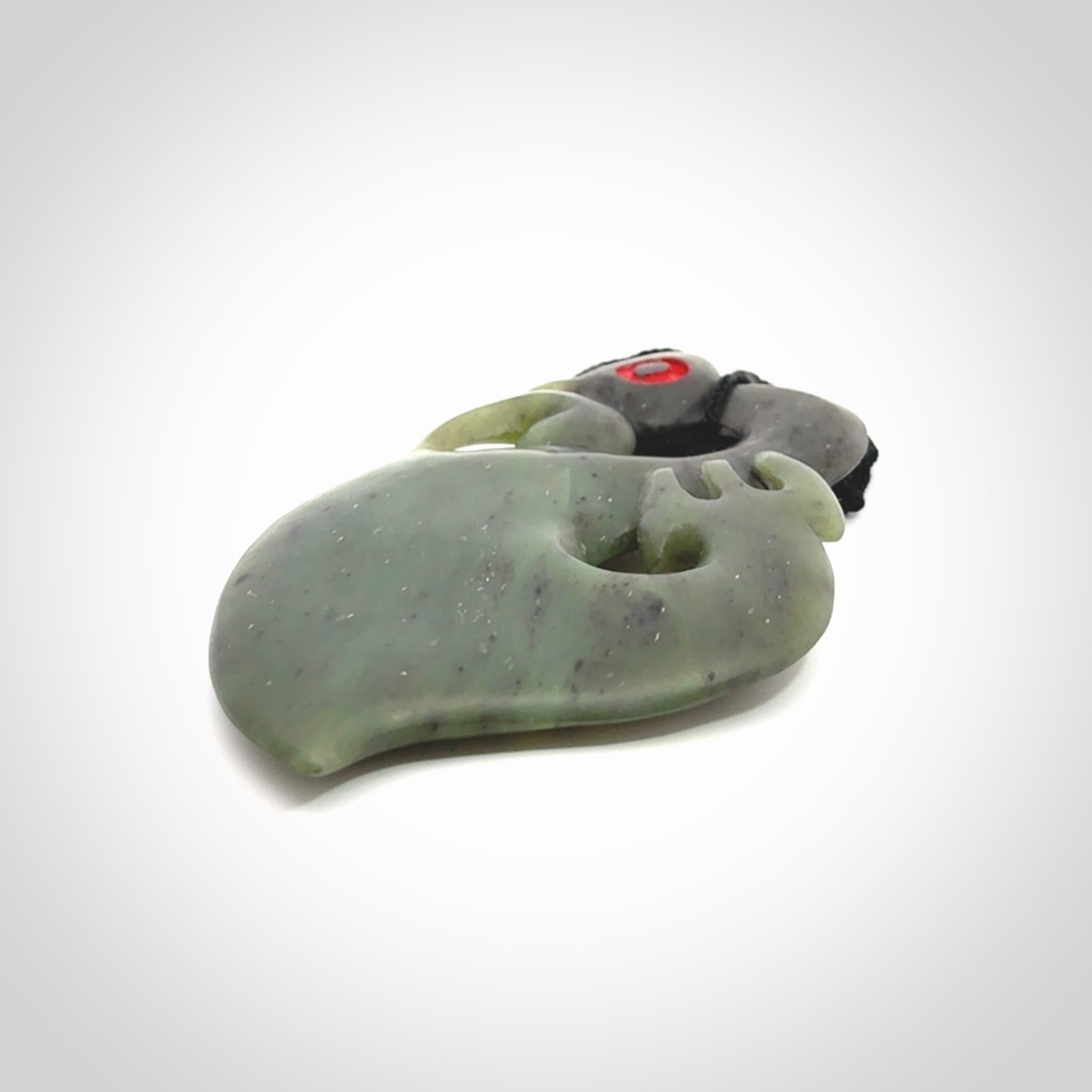 This picture shows a large traditional manaia pendant carved in New Zealand Jade.