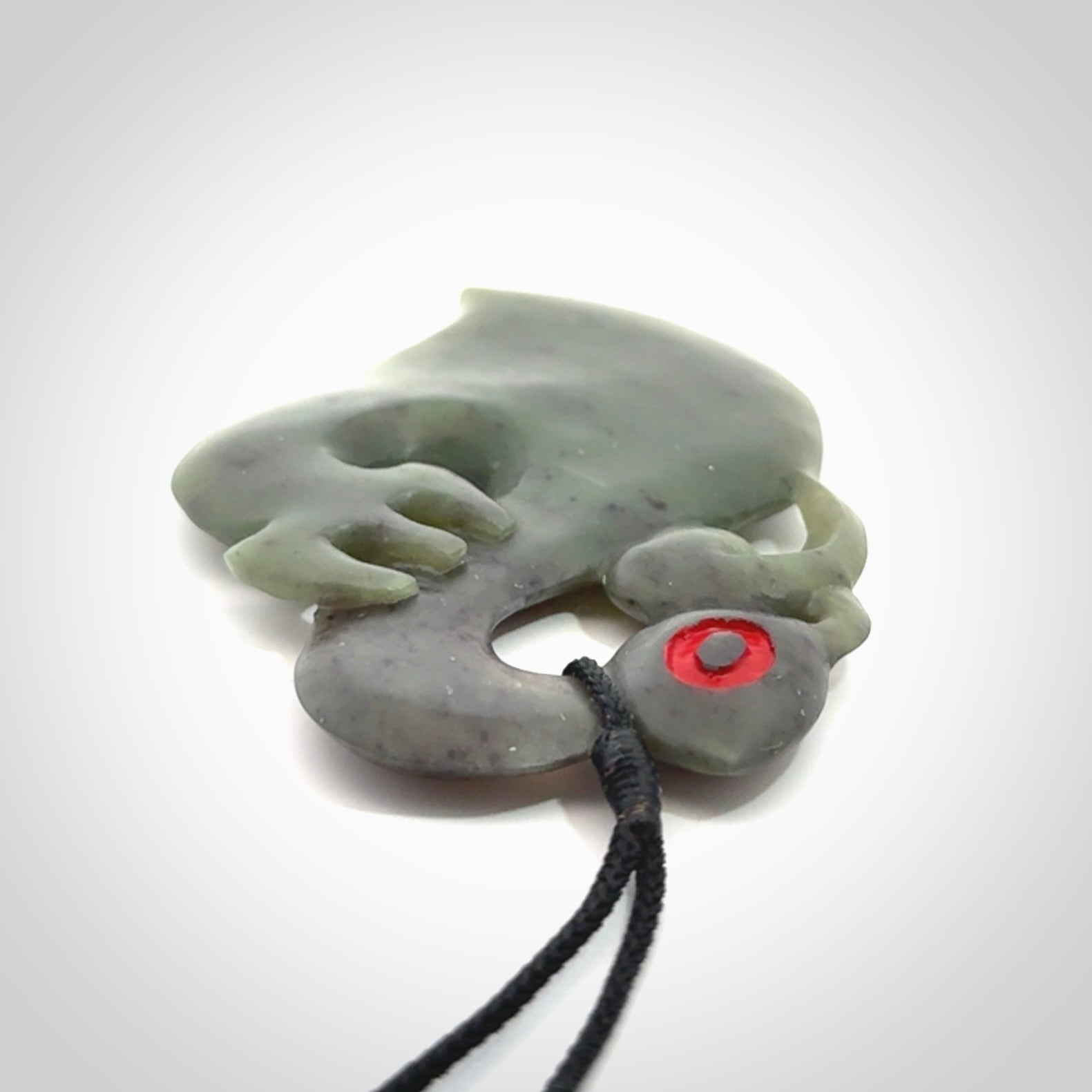 This picture shows a large traditional manaia pendant carved in New Zealand Jade.