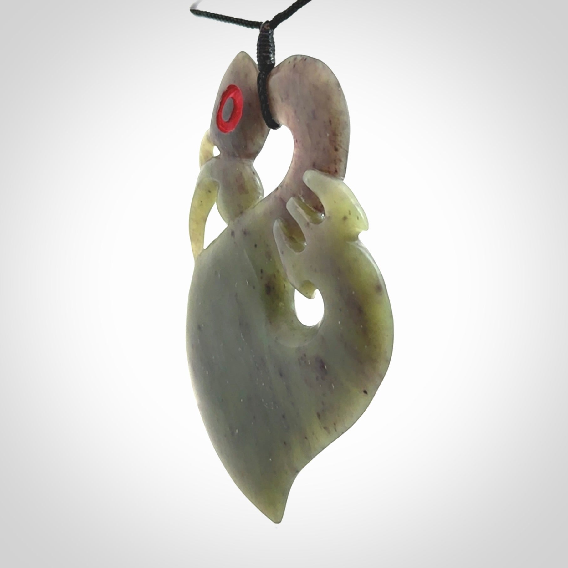 This picture shows a large traditional manaia pendant carved in New Zealand Jade.