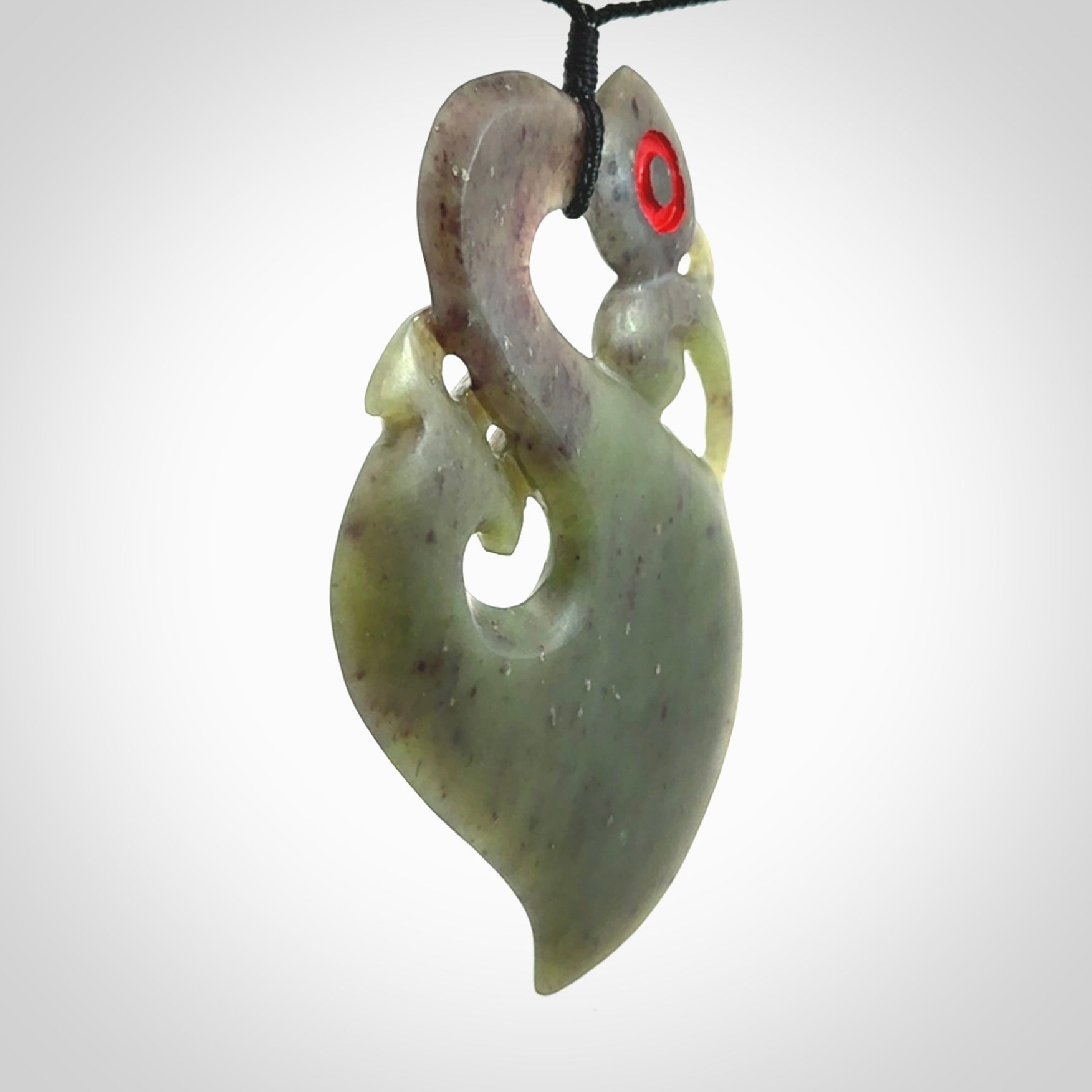 This picture shows a large traditional manaia pendant carved in New Zealand Jade.