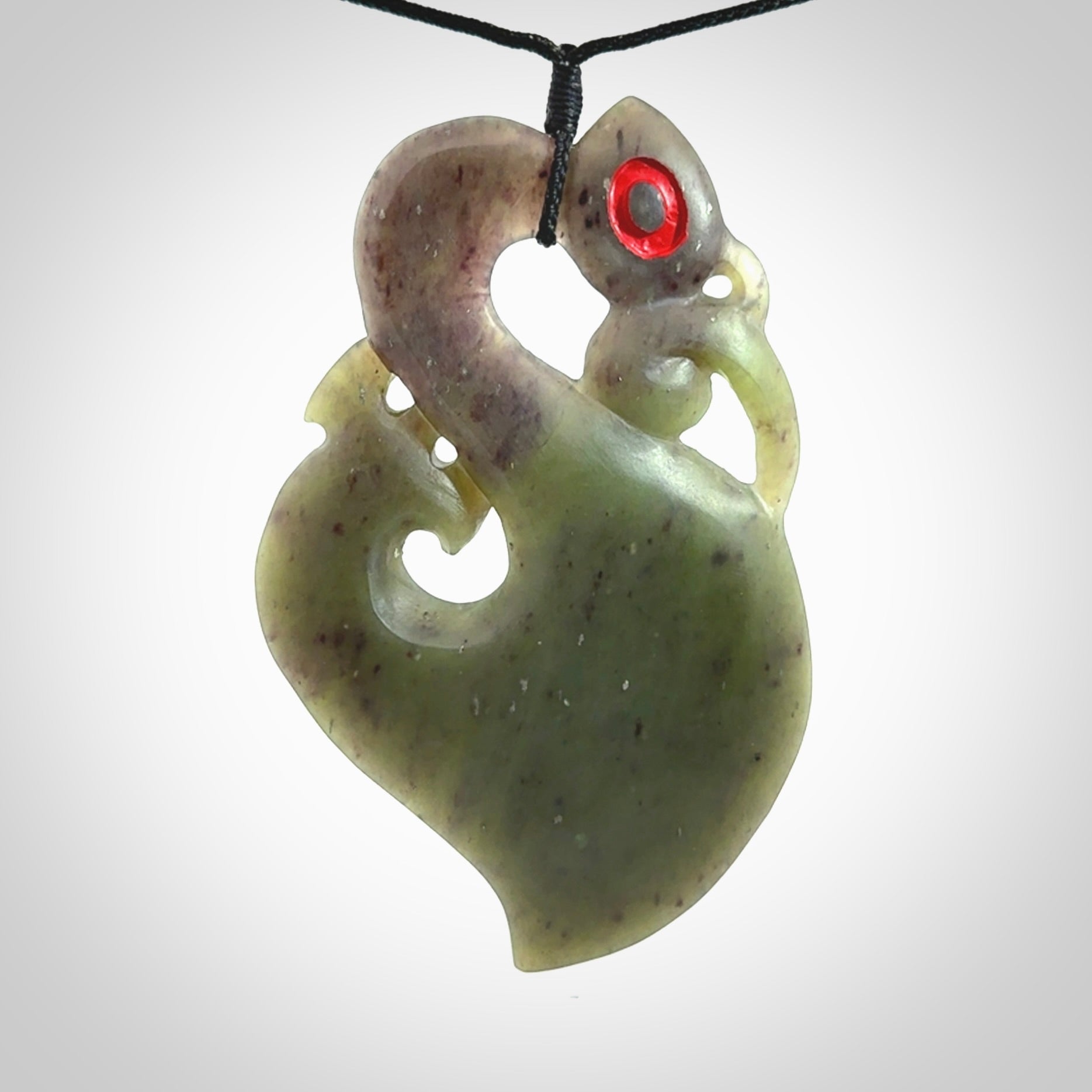 This picture shows a large traditional manaia pendant carved in New Zealand Jade.