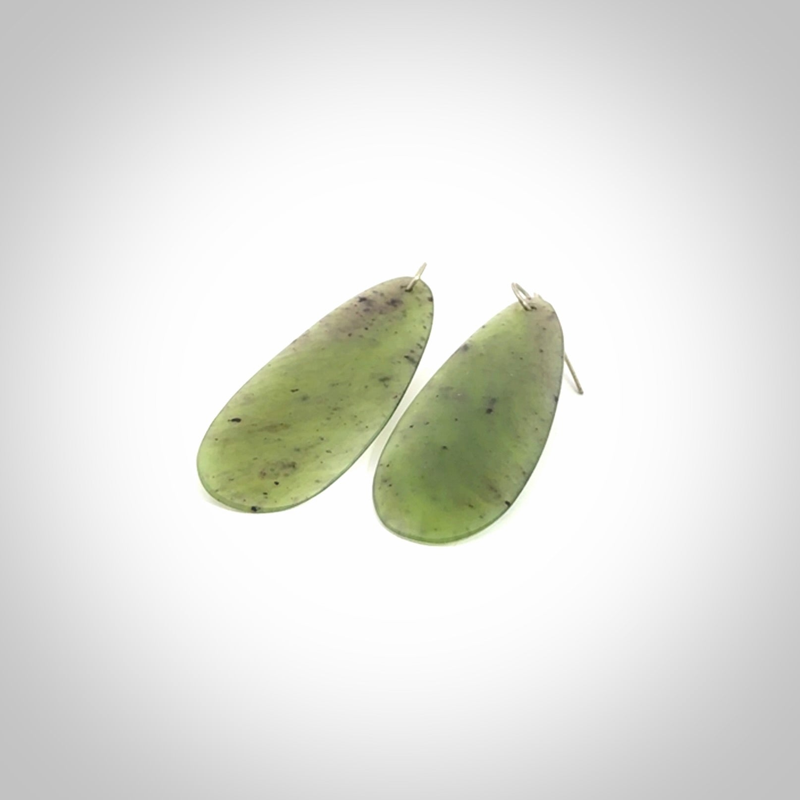 These are stunning large drop shaped jade earrings carved in New Zealand by Darren Hill. It is carved from a semi-translucent light green piece of New Zealand Jade and with Sterling Silver hooks.