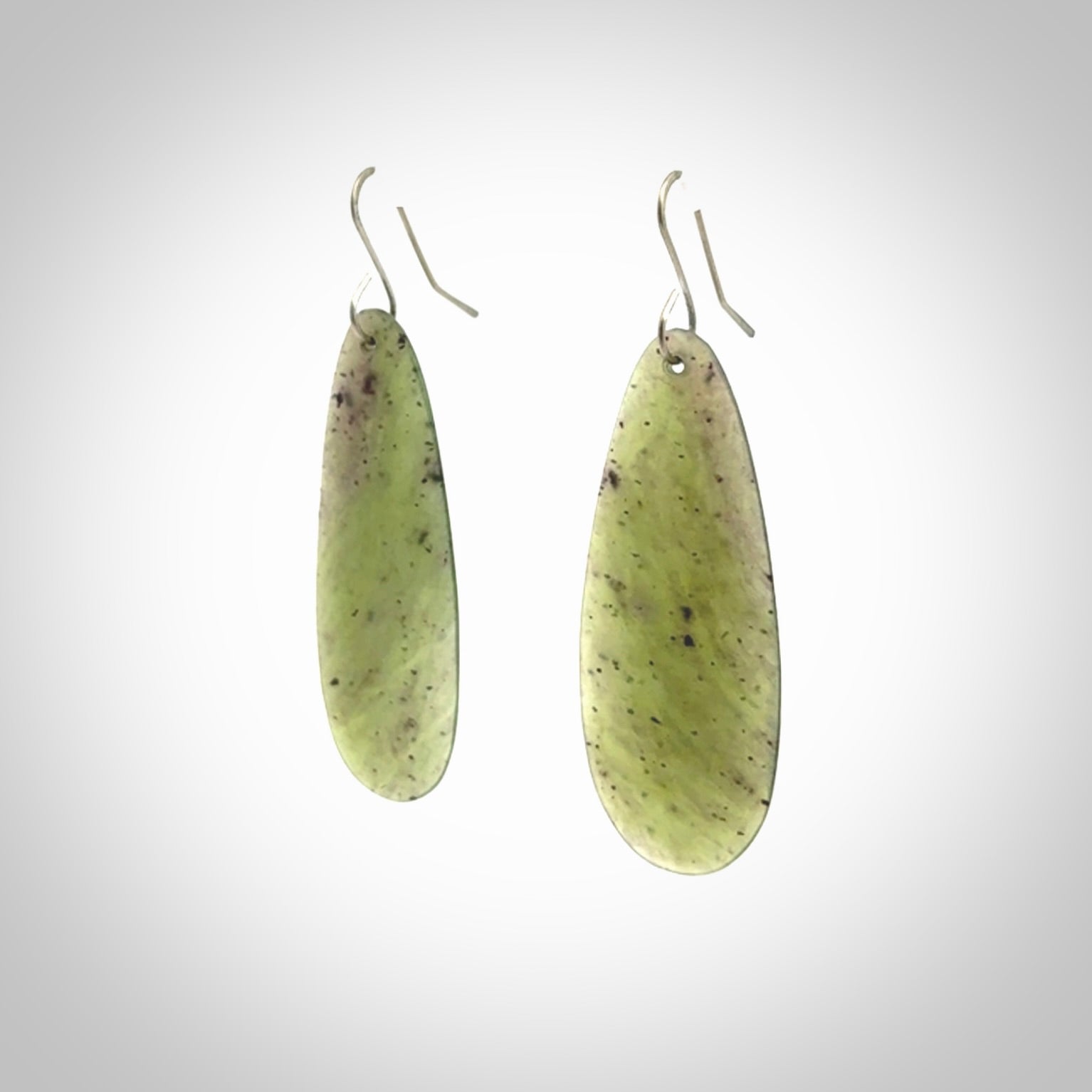 These are stunning large drop shaped jade earrings carved in New Zealand by Darren Hill. It is carved from a semi-translucent light green piece of New Zealand Jade and with Sterling Silver hooks.