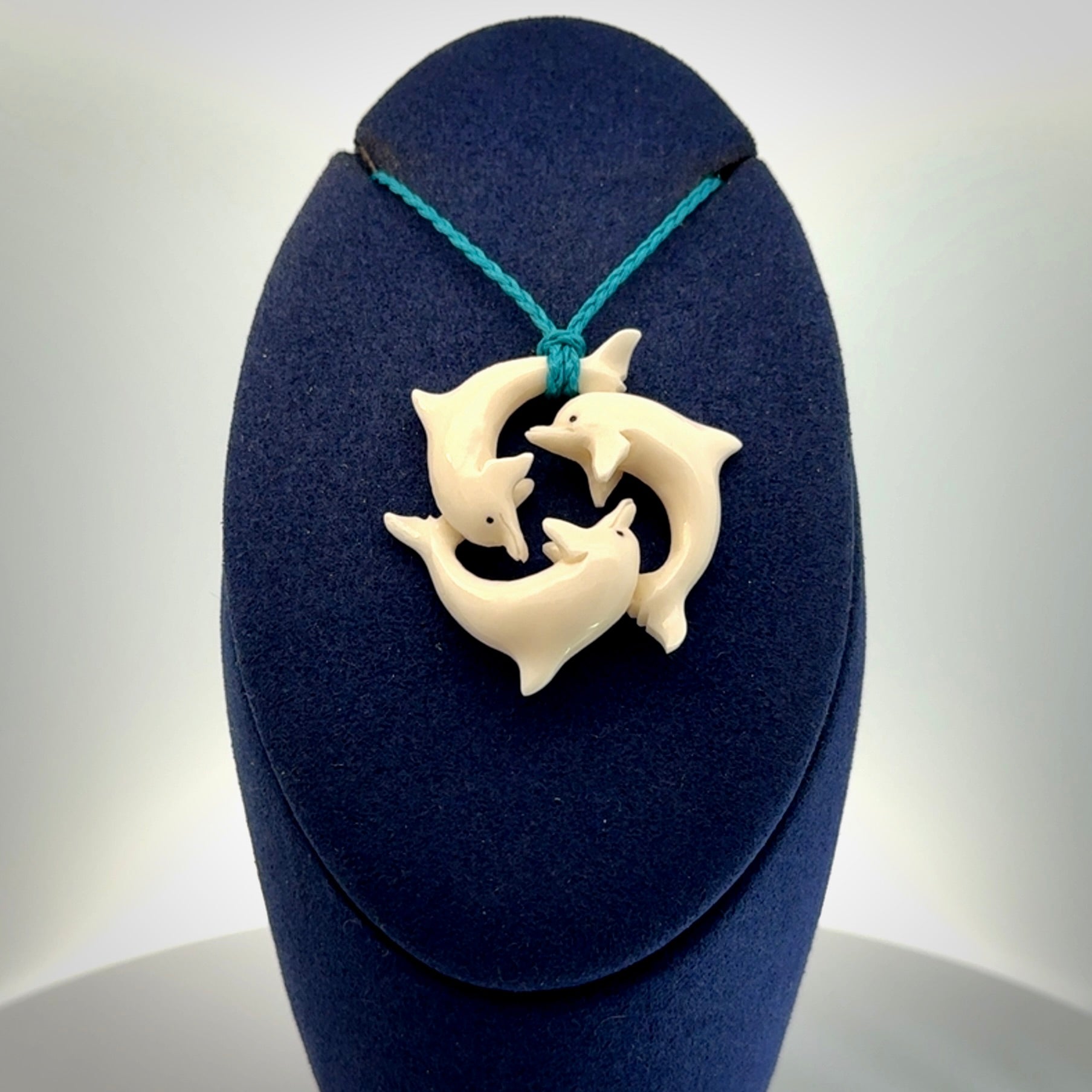 Hand carved dolphin trio pendant, made from natural bone by NZ Pacific. Hand made natural bone dolphin trilogy necklace, provided with an adjustable cord
