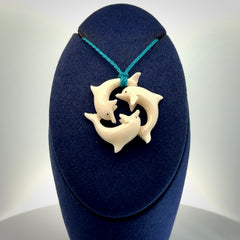 Hand carved dolphin trio pendant, made from natural bone by NZ Pacific. Hand made natural bone dolphin trilogy necklace, provided with an adjustable cord