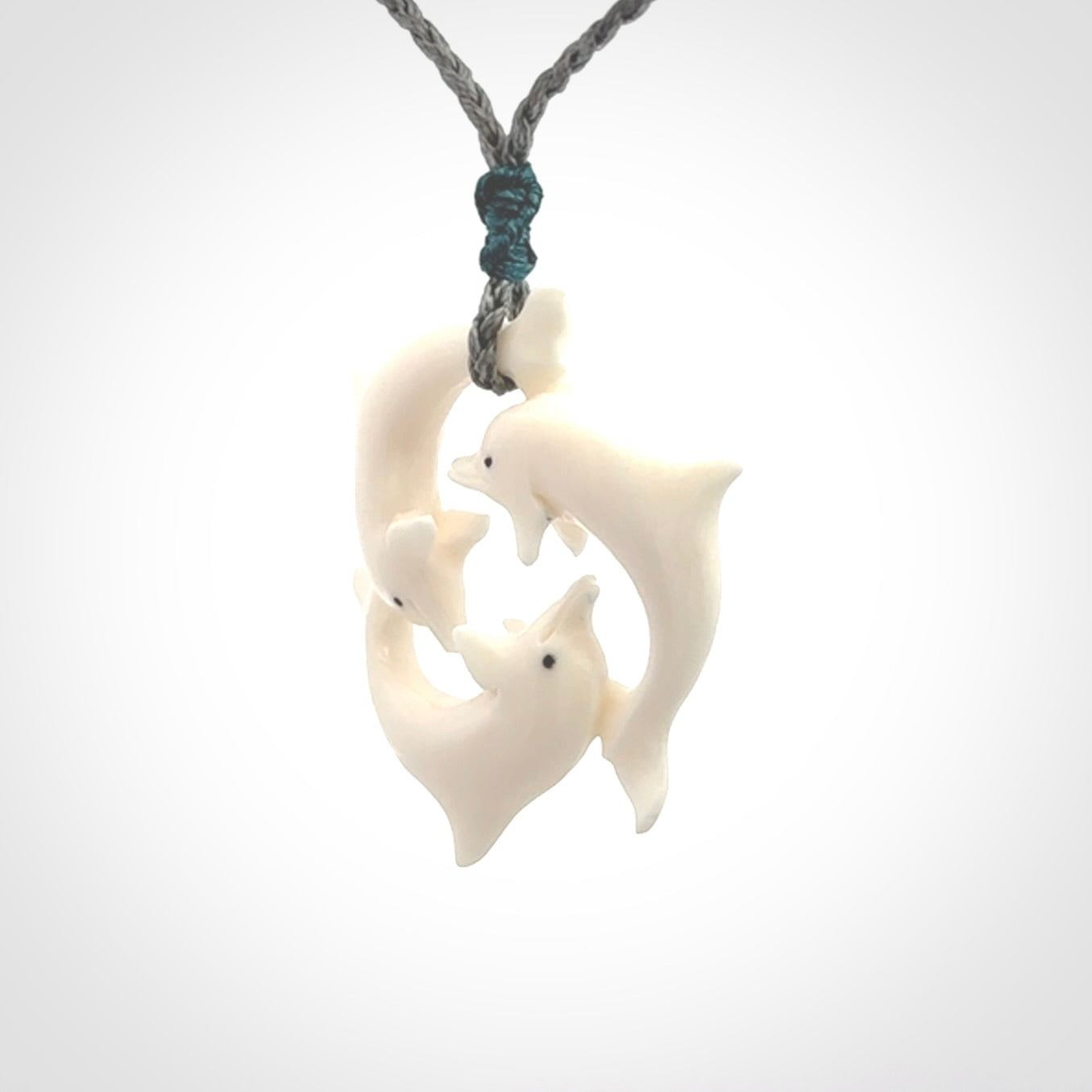Hand carved dolphin trio pendant, made from natural bone by NZ Pacific. Hand made natural bone dolphin trilogy necklace, provided with an adjustable cord