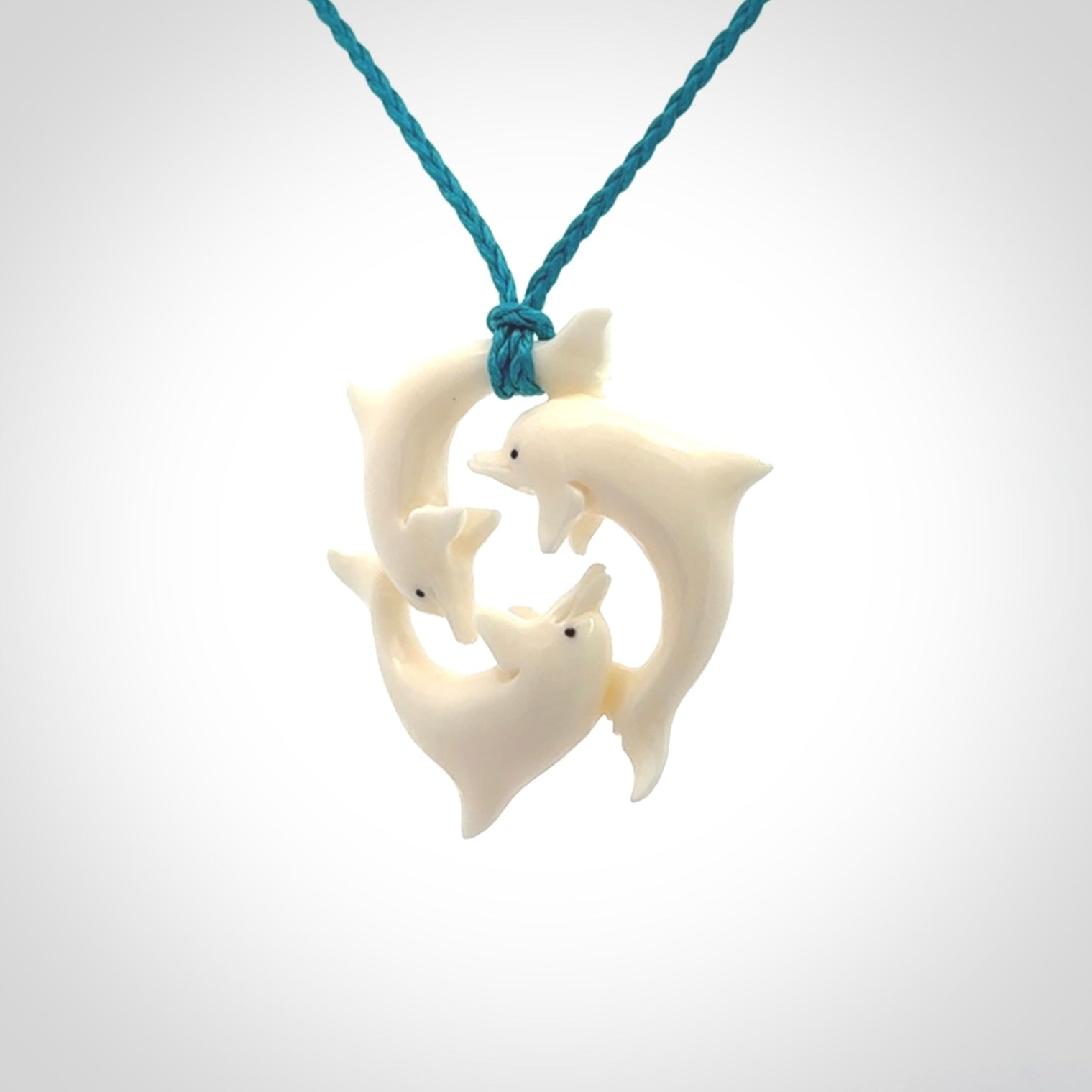 Hand carved dolphin trio pendant, made from natural bone by NZ Pacific. Hand made natural bone dolphin trilogy necklace, provided with an adjustable cord