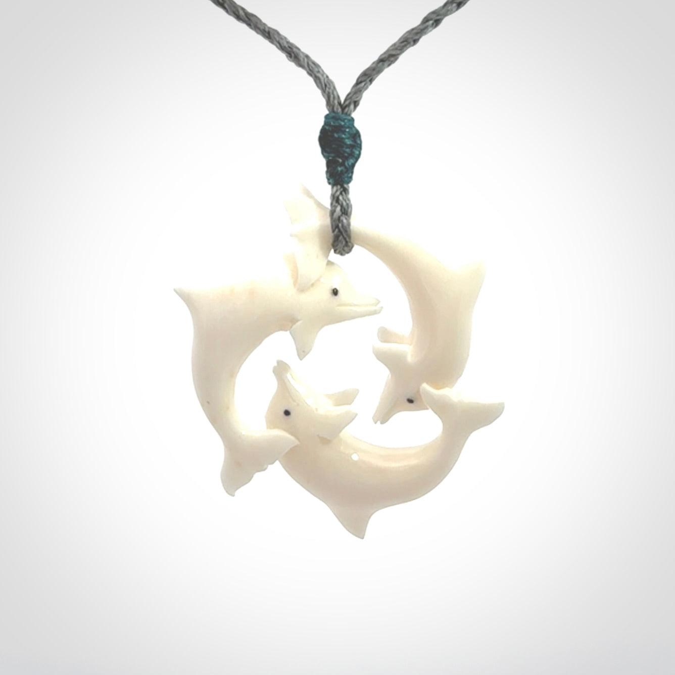 Hand carved dolphin trio pendant, made from natural bone by NZ Pacific. Hand made natural bone dolphin trilogy necklace, provided with an adjustable cord