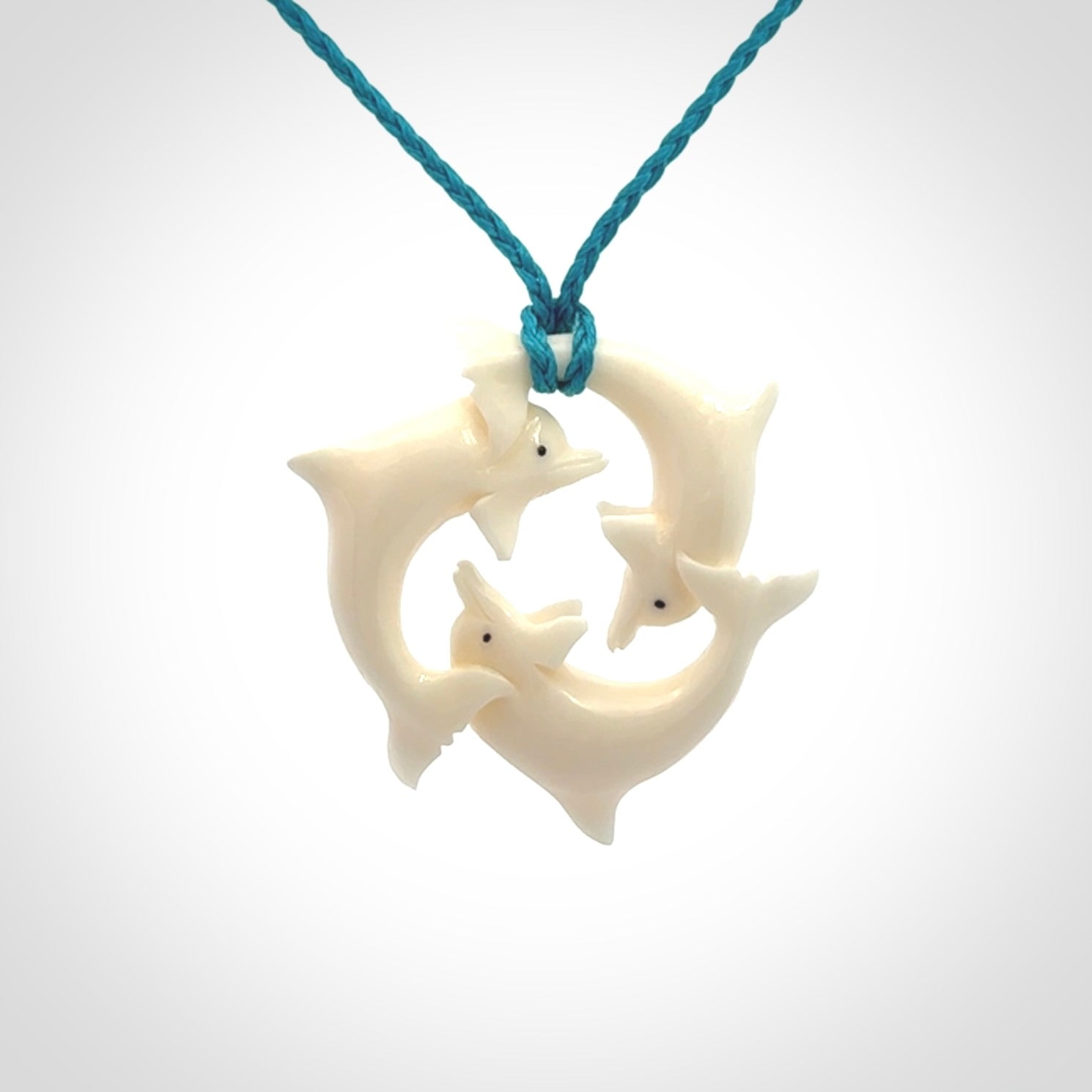 Hand carved dolphin trio pendant, made from natural bone by NZ Pacific. Hand made natural bone dolphin trilogy necklace, provided with an adjustable cord