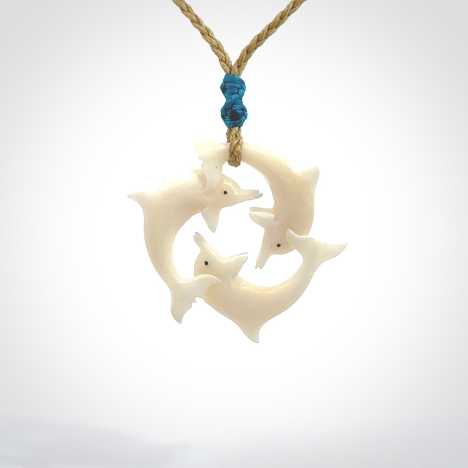 Hand carved dolphin trio pendant, made from natural bone by NZ Pacific. Hand made natural bone dolphin trilogy necklace, provided with an adjustable cord