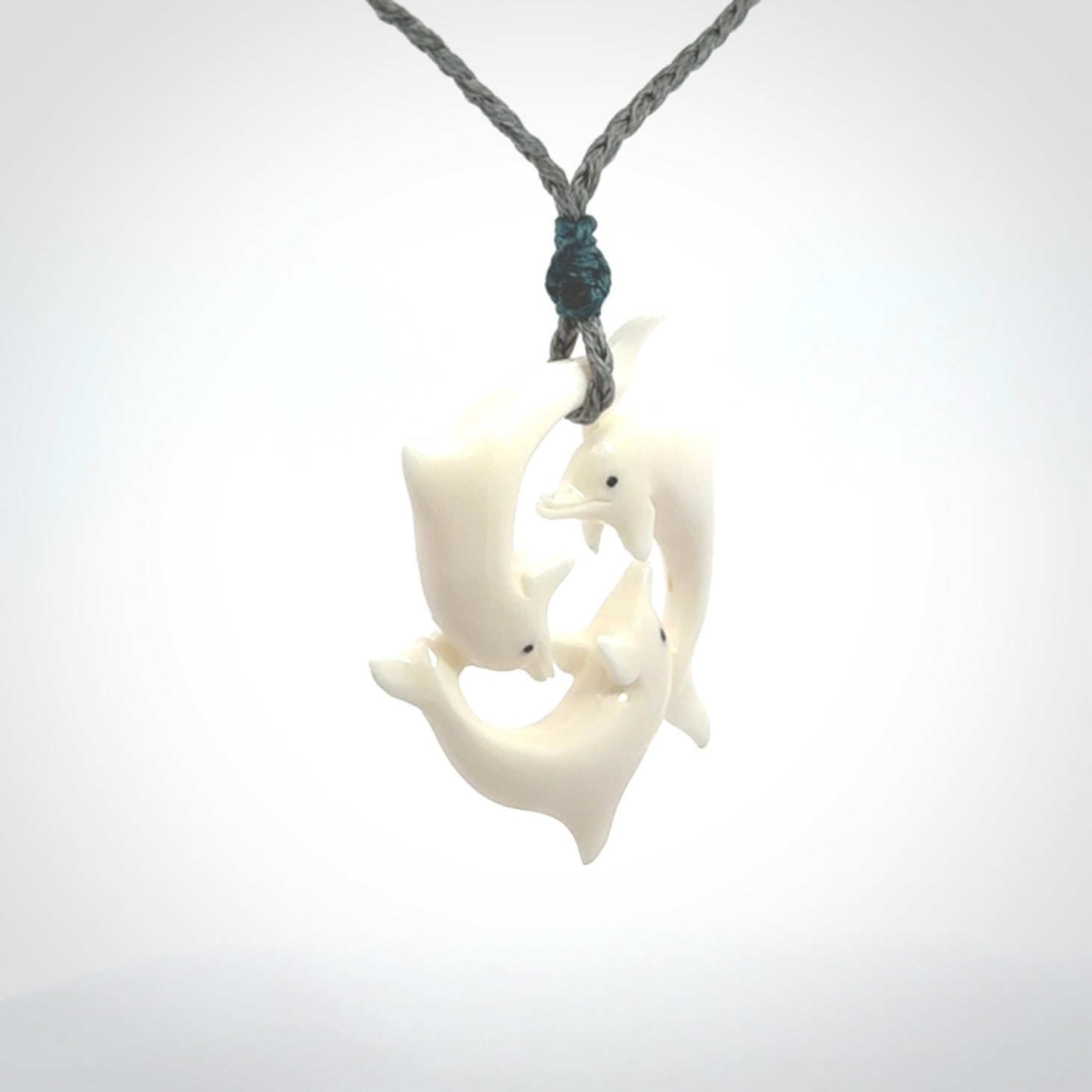 Hand carved dolphin trio pendant, made from natural bone by NZ Pacific. Hand made natural bone dolphin trilogy necklace, provided with an adjustable cord