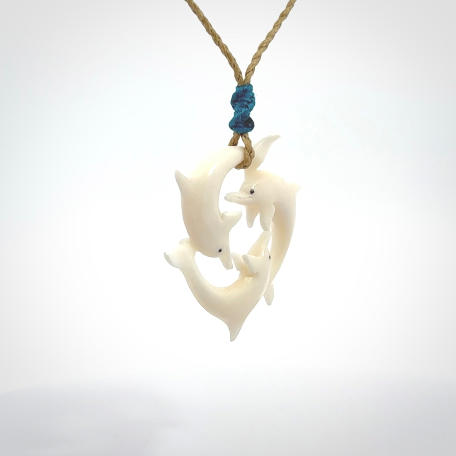 Hand carved dolphin trio pendant, made from natural bone by NZ Pacific. Hand made natural bone dolphin trilogy necklace, provided with an adjustable cord