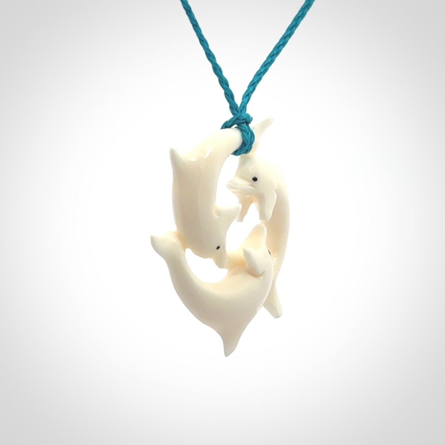Hand carved dolphin trio pendant, made from natural bone by NZ Pacific. Hand made natural bone dolphin trilogy necklace, provided with an adjustable cord