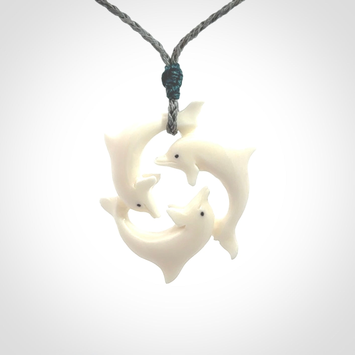 Hand carved dolphin trio pendant, made from natural bone by NZ Pacific. Hand made natural bone dolphin trilogy necklace, provided with an adjustable cord