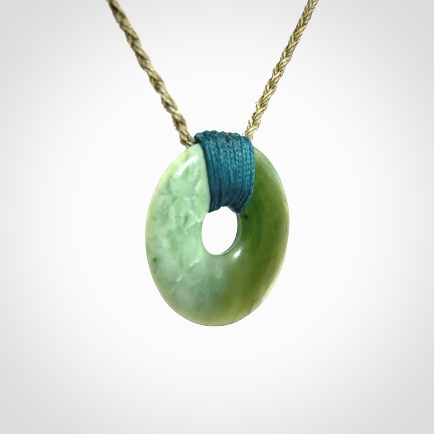 These are medium sized pendants - very finely carved. They are New Zealand Jade discs with a centre hole. It is suspended from a cord which is adjustable. These are beautiful pieces of expressive jade jewellery. Unique New Zealand made pendants for men and women. Perfect gifts for all.