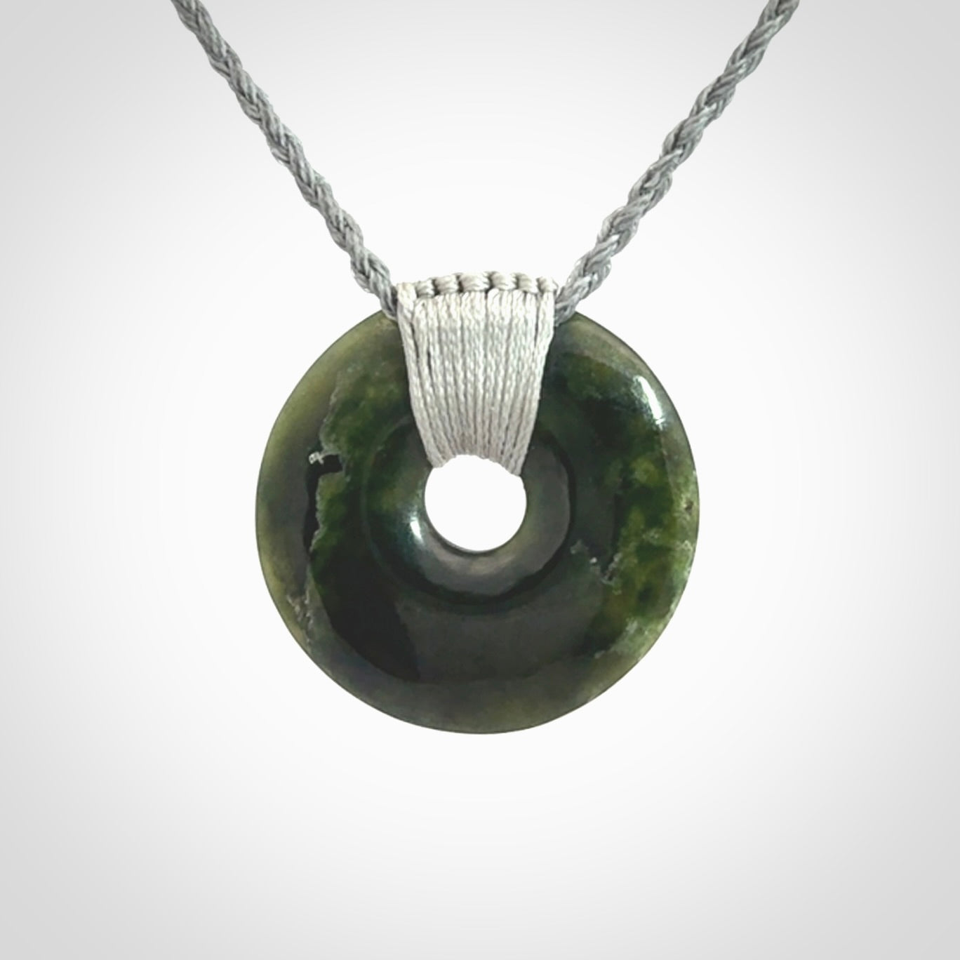 These are medium sized pendants - very finely carved. They are New Zealand Jade discs with a centre hole. It is suspended from a cord which is adjustable. These are beautiful pieces of expressive jade jewellery. Unique New Zealand made pendants for men and women. Perfect gifts for all.