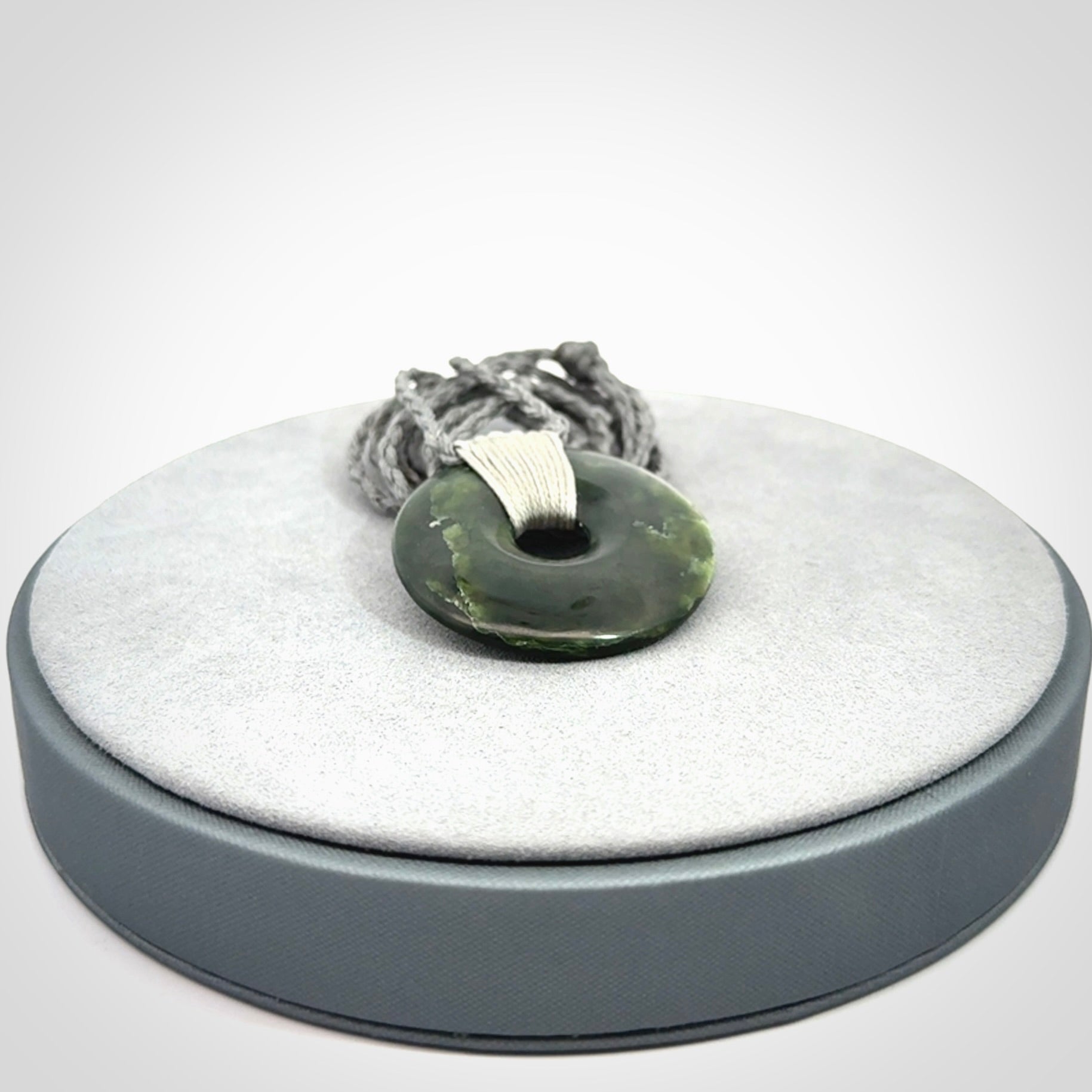 These are medium sized pendants - very finely carved. They are New Zealand Jade discs with a centre hole. It is suspended from a cord which is adjustable. These are beautiful pieces of expressive jade jewellery. Unique New Zealand made pendants for men and women. Perfect gifts for all.