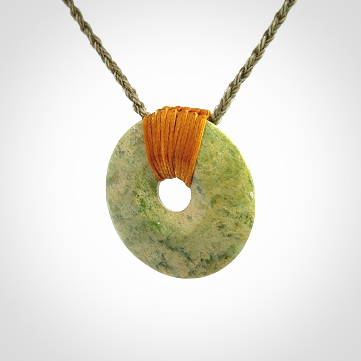These are medium sized pendants - very finely carved. They are New Zealand Jade discs with a centre hole. It is suspended from a cord which is adjustable. These are beautiful pieces of expressive jade jewellery. Unique New Zealand made pendants for men and women. Perfect gifts for all.