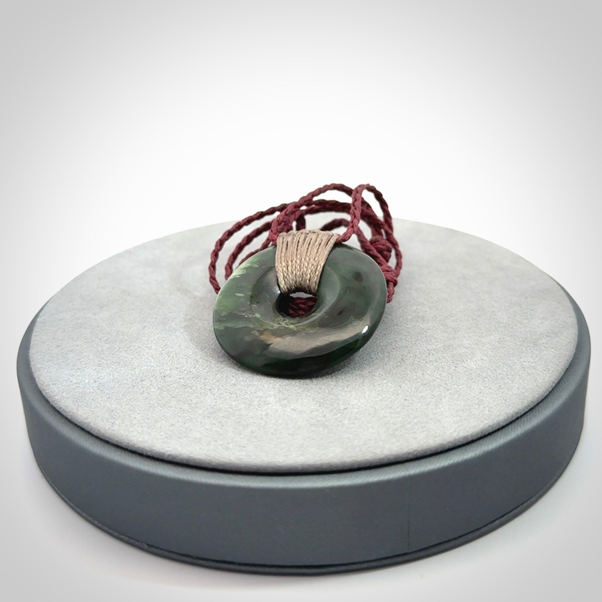 These are medium sized pendants - very finely carved. They are New Zealand Jade discs with a centre hole. It is suspended from a cord which is adjustable. These are beautiful pieces of expressive jade jewellery. Unique New Zealand made pendants for men and women. Perfect gifts for all.