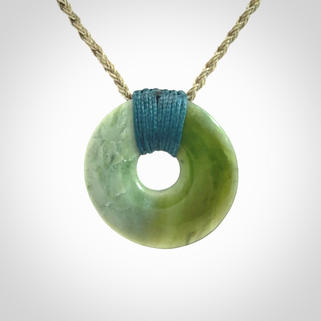 These are medium sized pendants - very finely carved. They are New Zealand Jade discs with a centre hole. It is suspended from a cord which is adjustable. These are beautiful pieces of expressive jade jewellery. Unique New Zealand made pendants for men and women. Perfect gifts for all.