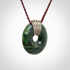 These are medium sized pendants - very finely carved. They are New Zealand Jade discs with a centre hole. It is suspended from a cord which is adjustable. These are beautiful pieces of expressive jade jewellery. Unique New Zealand made pendants for men and women. Perfect gifts for all.
