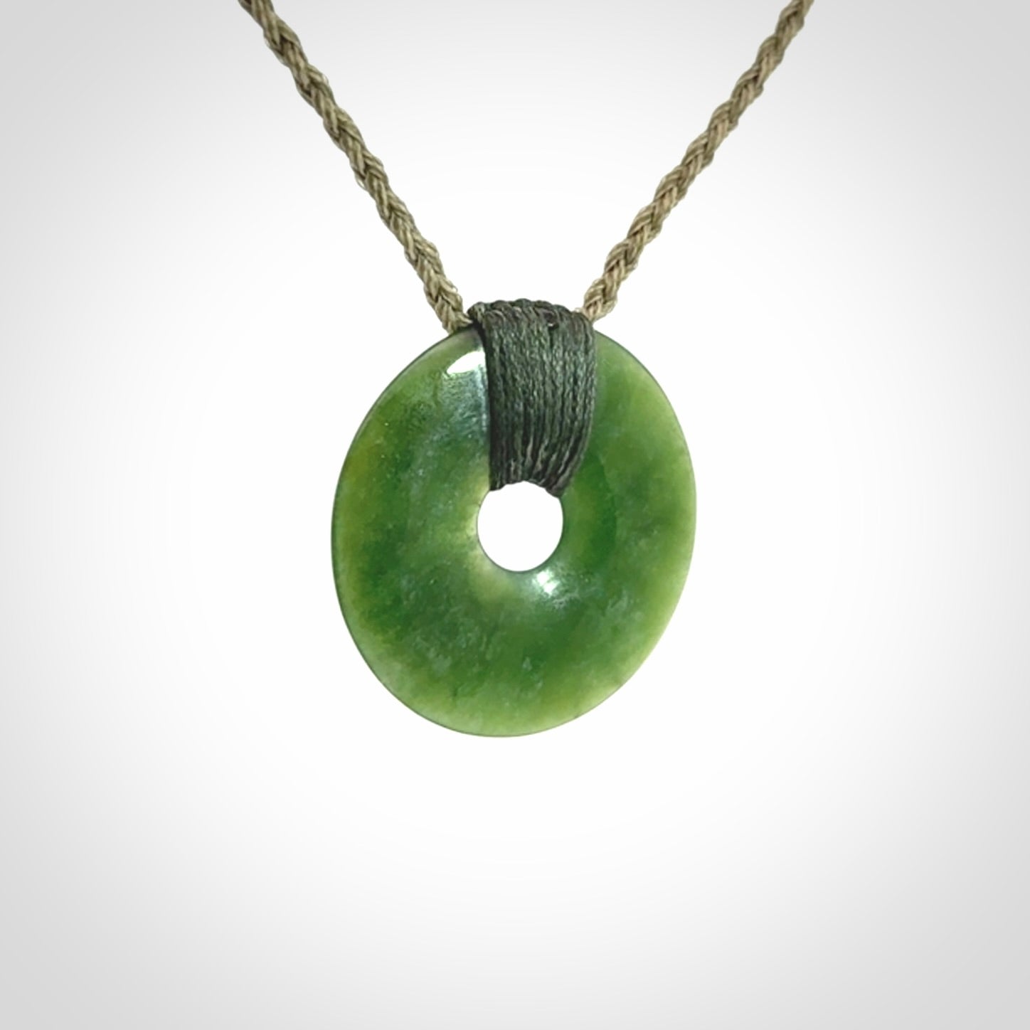 These are medium sized pendants - very finely carved. They are New Zealand Jade discs with a centre hole. It is suspended from a cord which is adjustable. These are beautiful pieces of expressive jade jewellery. Unique New Zealand made pendants for men and women. Perfect gifts for all.