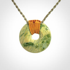 These are medium sized pendants - very finely carved. They are New Zealand Jade discs with a centre hole. It is suspended from a cord which is adjustable. These are beautiful pieces of expressive jade jewellery. Unique New Zealand made pendants for men and women. Perfect gifts for all.