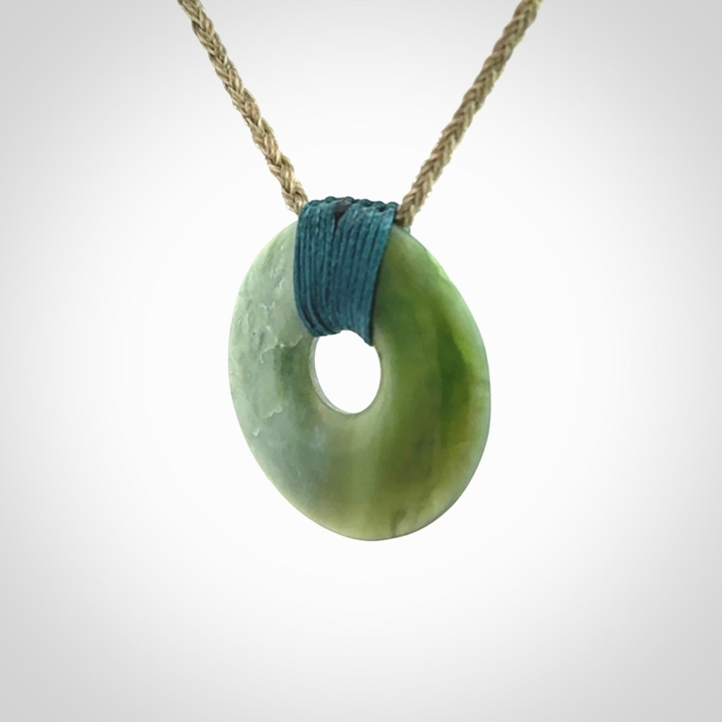 These are medium sized pendants - very finely carved. They are New Zealand Jade discs with a centre hole. It is suspended from a cord which is adjustable. These are beautiful pieces of expressive jade jewellery. Unique New Zealand made pendants for men and women. Perfect gifts for all.