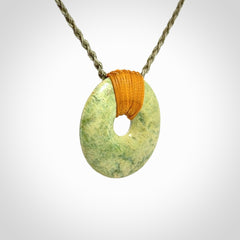 These are medium sized pendants - very finely carved. They are New Zealand Jade discs with a centre hole. It is suspended from a cord which is adjustable. These are beautiful pieces of expressive jade jewellery. Unique New Zealand made pendants for men and women. Perfect gifts for all.
