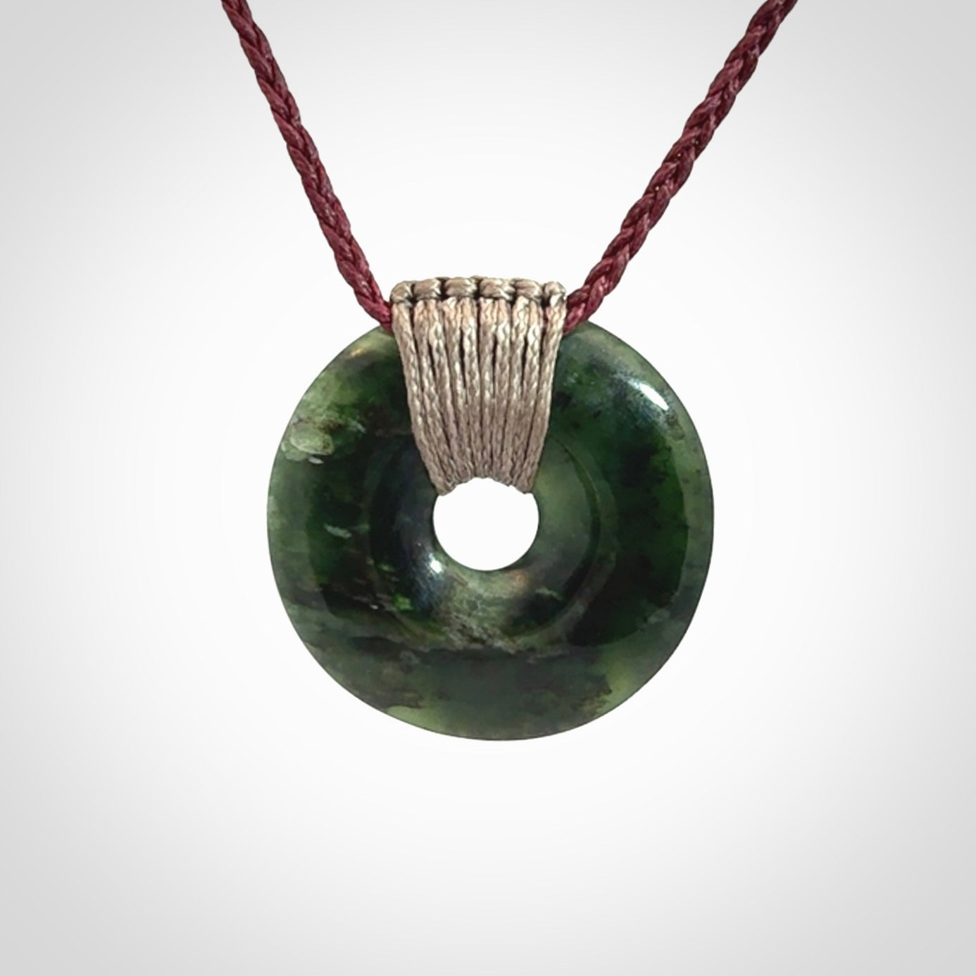 These are medium sized pendants - very finely carved. They are New Zealand Jade discs with a centre hole. It is suspended from a cord which is adjustable. These are beautiful pieces of expressive jade jewellery. Unique New Zealand made pendants for men and women. Perfect gifts for all.
