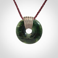 These are medium sized pendants - very finely carved. They are New Zealand Jade discs with a centre hole. It is suspended from a cord which is adjustable. These are beautiful pieces of expressive jade jewellery. Unique New Zealand made pendants for men and women. Perfect gifts for all.