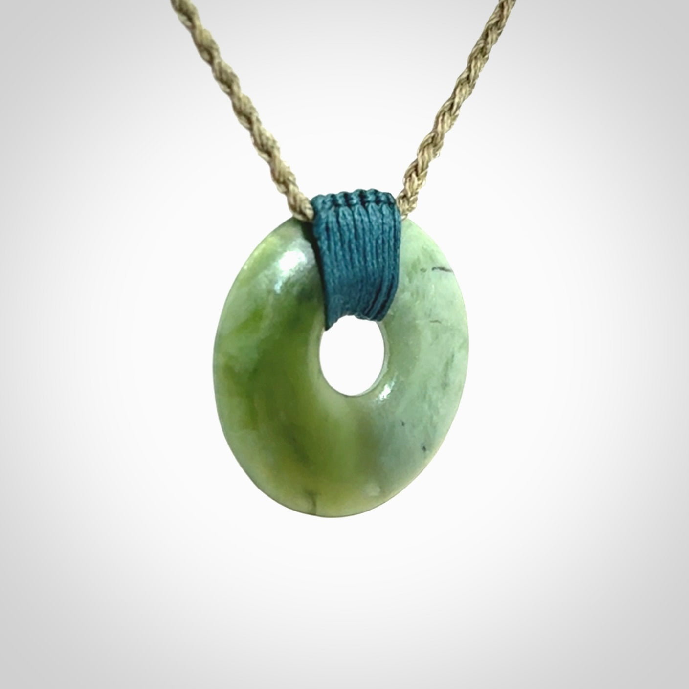 These are medium sized pendants - very finely carved. They are New Zealand Jade discs with a centre hole. It is suspended from a cord which is adjustable. These are beautiful pieces of expressive jade jewellery. Unique New Zealand made pendants for men and women. Perfect gifts for all.