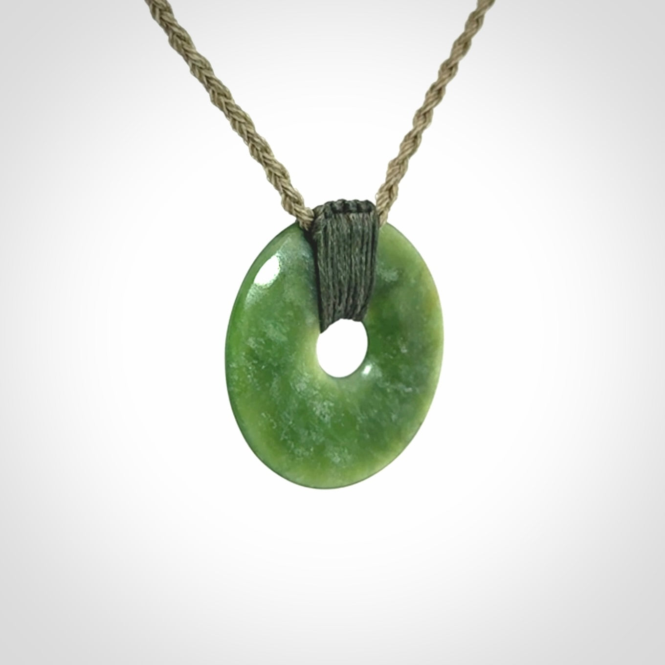 These are medium sized pendants - very finely carved. They are New Zealand Jade discs with a centre hole. It is suspended from a cord which is adjustable. These are beautiful pieces of expressive jade jewellery. Unique New Zealand made pendants for men and women. Perfect gifts for all.