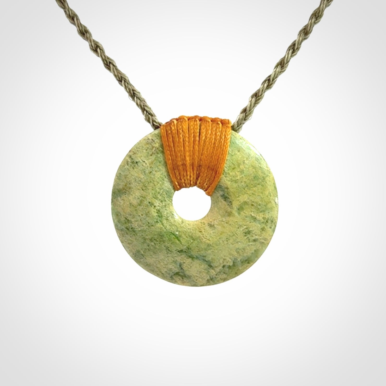 These are medium sized pendants - very finely carved. They are New Zealand Jade discs with a centre hole. It is suspended from a cord which is adjustable. These are beautiful pieces of expressive jade jewellery. Unique New Zealand made pendants for men and women. Perfect gifts for all.