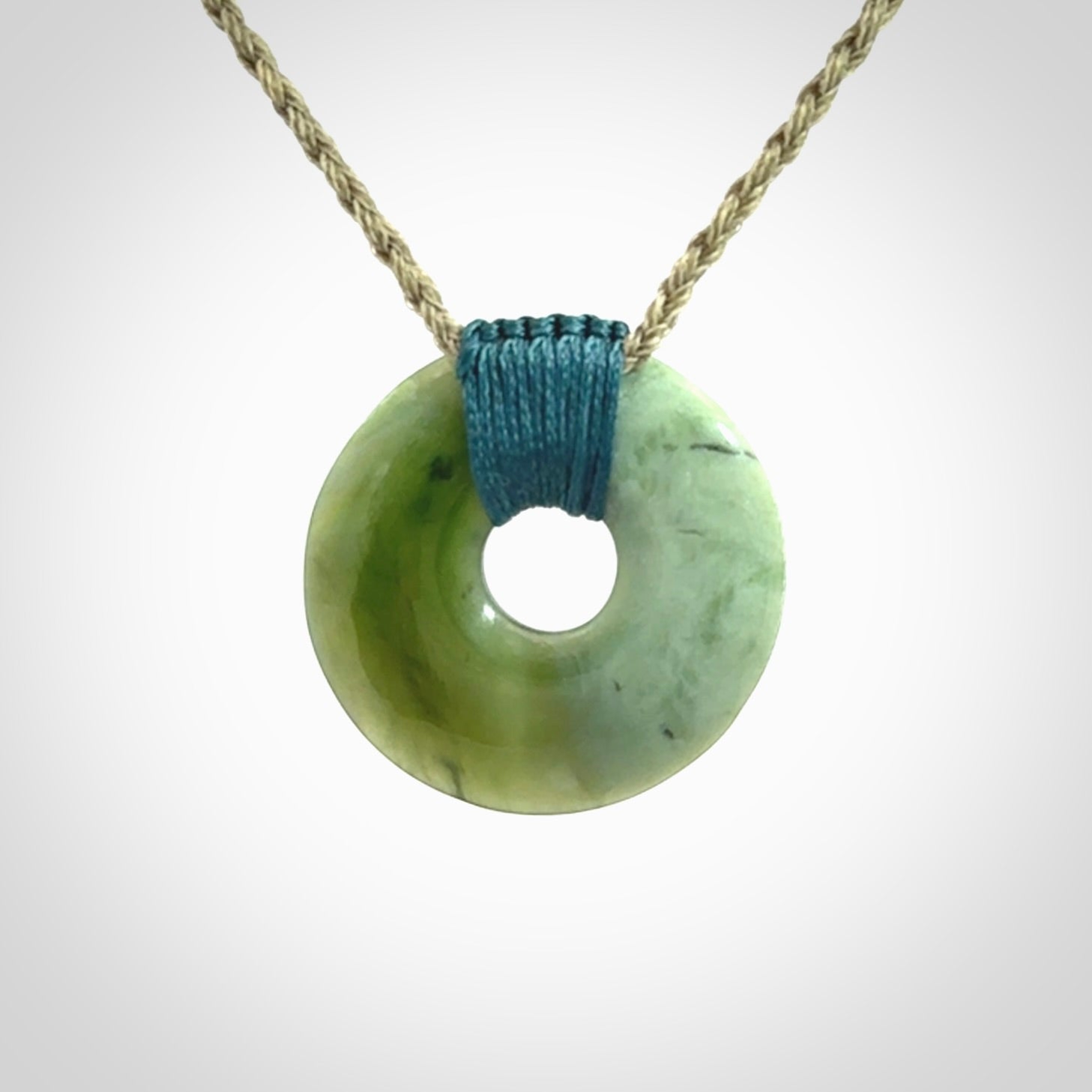 These are medium sized pendants - very finely carved. They are New Zealand Jade discs with a centre hole. It is suspended from a cord which is adjustable. These are beautiful pieces of expressive jade jewellery. Unique New Zealand made pendants for men and women. Perfect gifts for all.