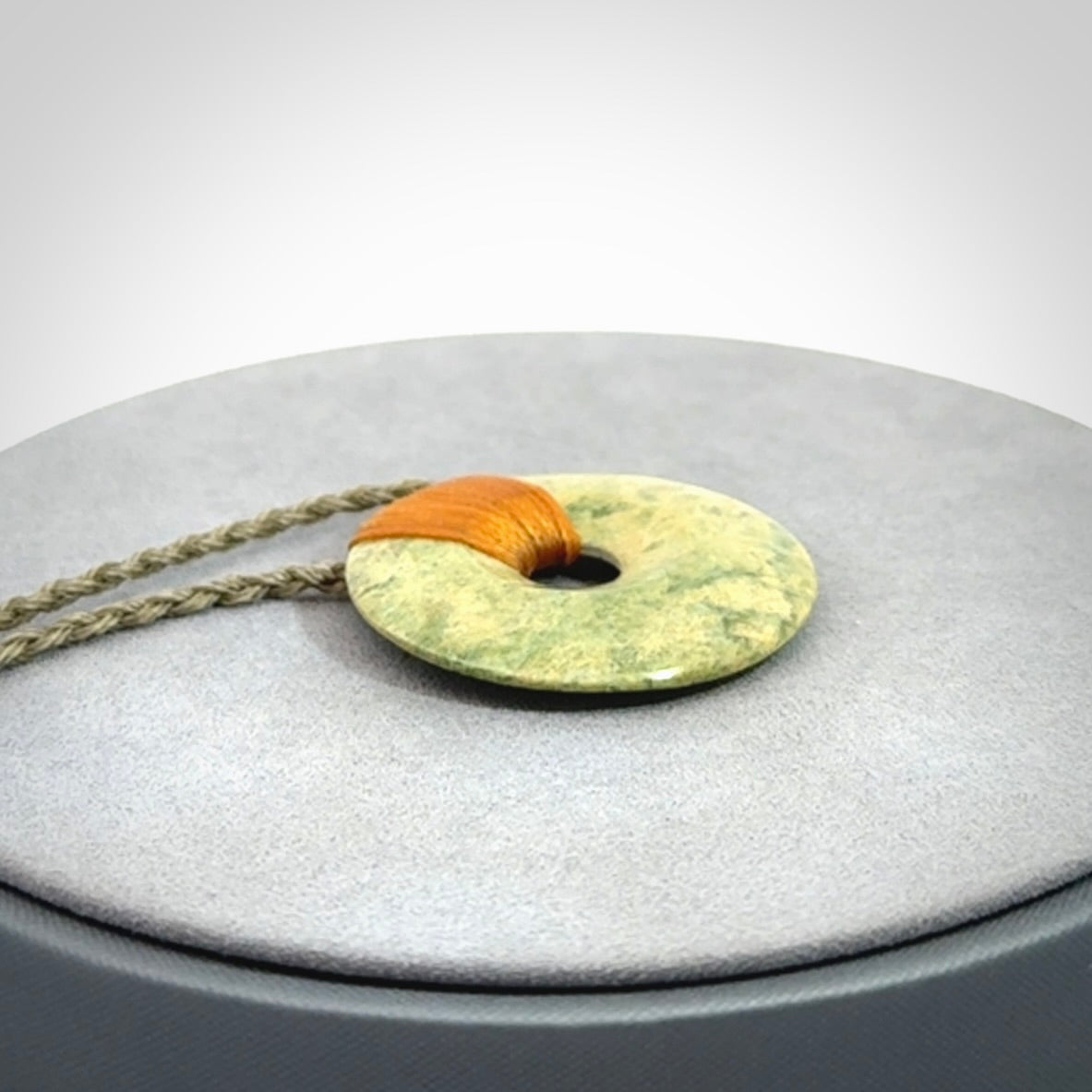 These are medium sized pendants - very finely carved. They are New Zealand Jade discs with a centre hole. It is suspended from a cord which is adjustable. These are beautiful pieces of expressive jade jewellery. Unique New Zealand made pendants for men and women. Perfect gifts for all.