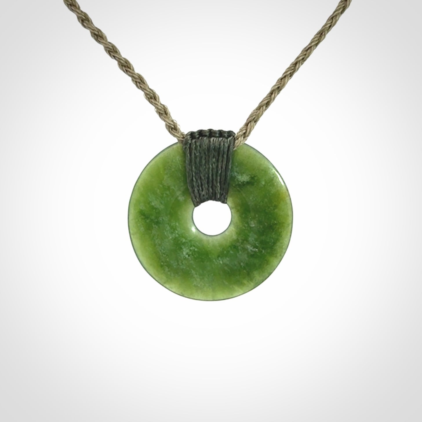 These are medium sized pendants - very finely carved. They are New Zealand Jade discs with a centre hole. It is suspended from a cord which is adjustable. These are beautiful pieces of expressive jade jewellery. Unique New Zealand made pendants for men and women. Perfect gifts for all.