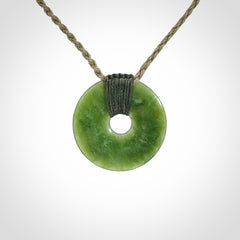 These are medium sized pendants - very finely carved. They are New Zealand Jade discs with a centre hole. It is suspended from a cord which is adjustable. These are beautiful pieces of expressive jade jewellery. Unique New Zealand made pendants for men and women. Perfect gifts for all.