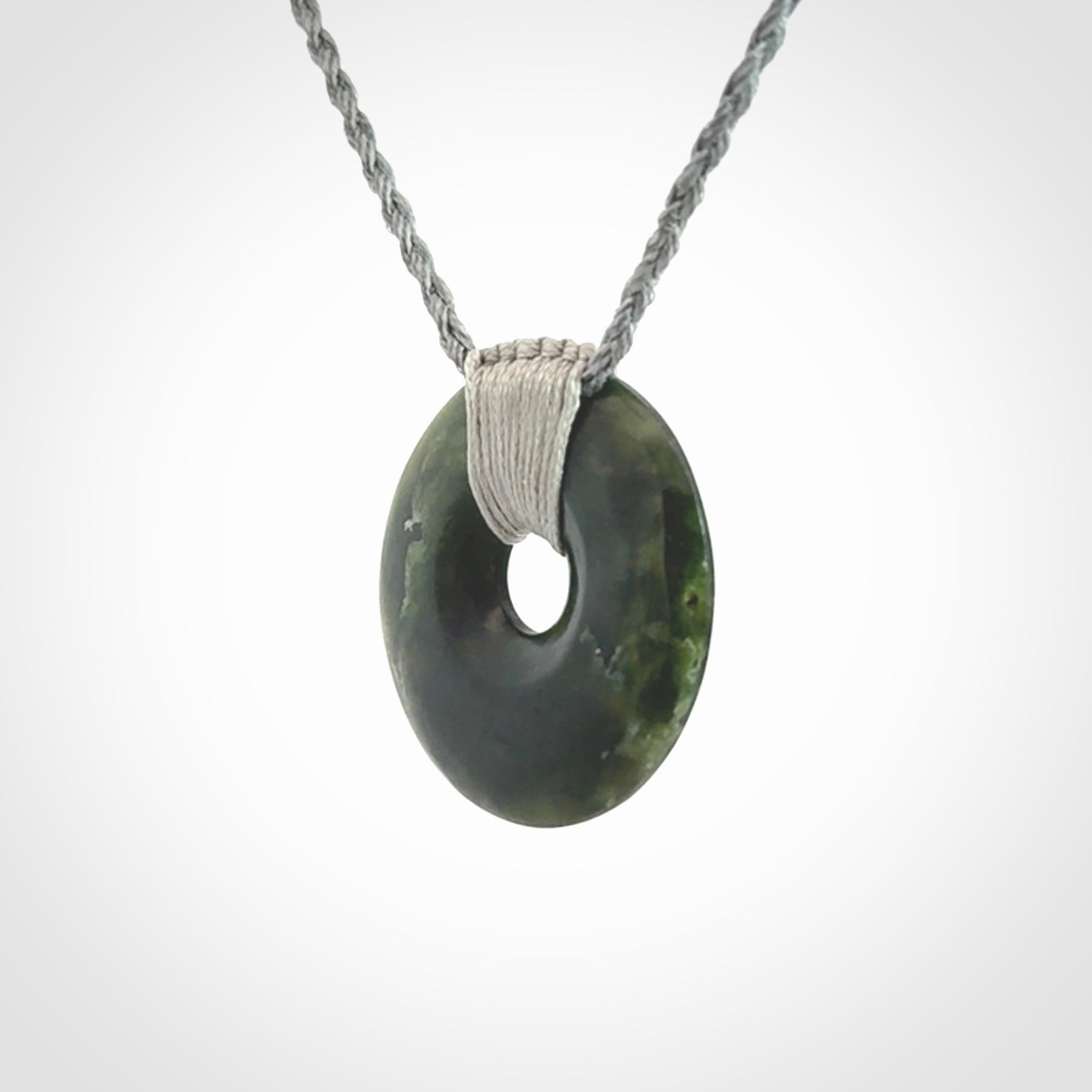 These are medium sized pendants - very finely carved. They are New Zealand Jade discs with a centre hole. It is suspended from a cord which is adjustable. These are beautiful pieces of expressive jade jewellery. Unique New Zealand made pendants for men and women. Perfect gifts for all.