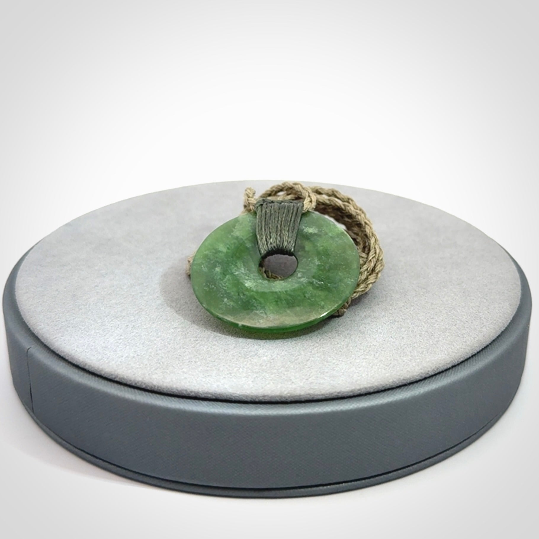 These are medium sized pendants - very finely carved. They are New Zealand Jade discs with a centre hole. It is suspended from a cord which is adjustable. These are beautiful pieces of expressive jade jewellery. Unique New Zealand made pendants for men and women. Perfect gifts for all.