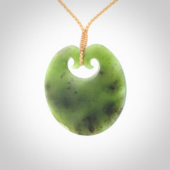 This picture shows a large contemporary pendant carved for us in New Zealand jade. The cord is a four-plait, adjustable beige coloured necklace.