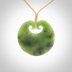 This picture shows a large contemporary pendant carved for us in New Zealand jade. The cord is a four-plait, adjustable beige coloured necklace.