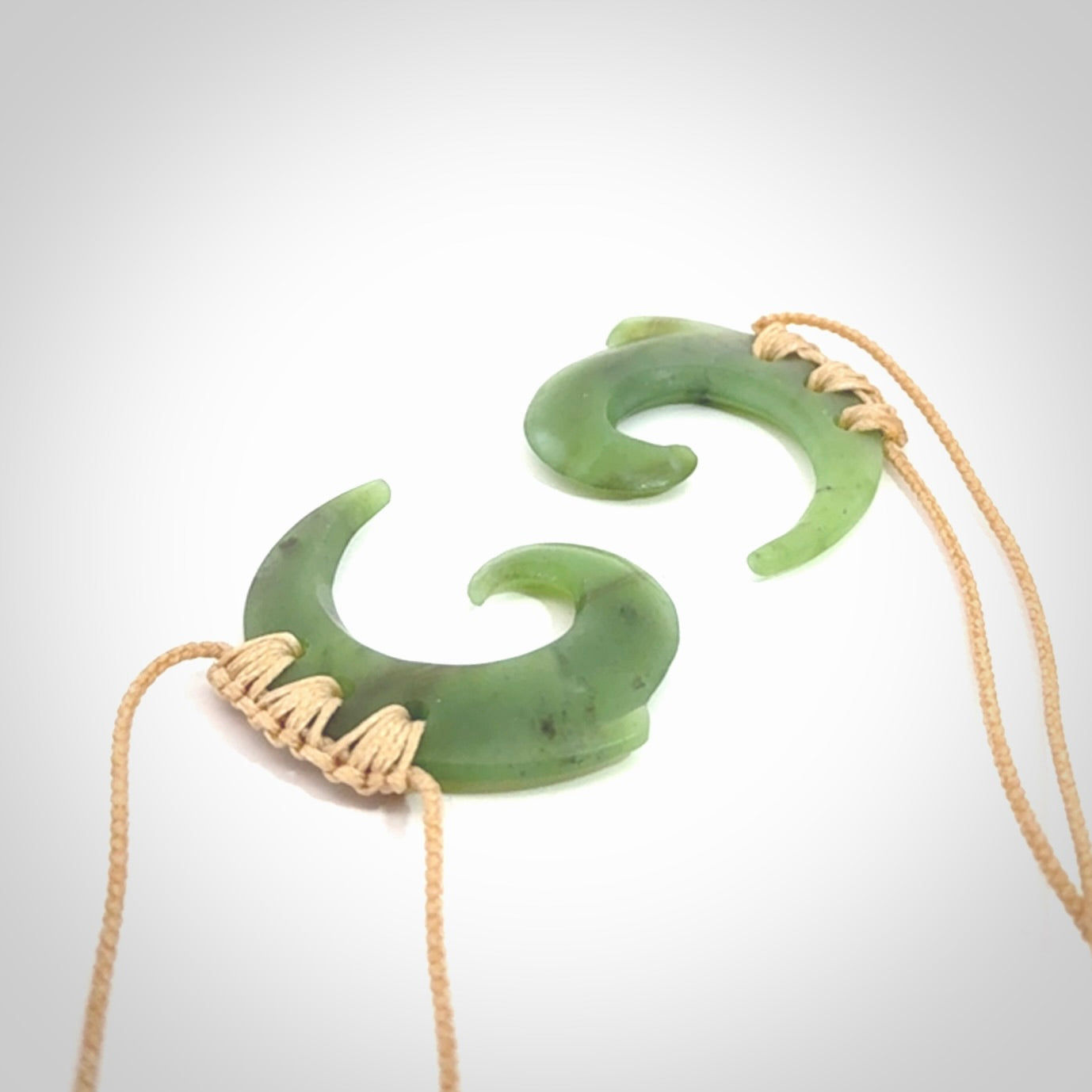 Two Jade koru partner pendants. Necklace hand carved in New Zealand jade, pounamu by NZ Pacific. These are partner pendants that represent partnerships. The jade is a beautiful bright green and we have suspended these on adjustable cords so that you can position the pendant where it suits you best. Postage is included in the price and we ship worldwide.