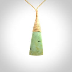 This photo shows a medium sized jade drop shaped pendant. It a a lovely varied green and light orange New Zealand Flower jade. The cord is a four plait beige and is adjustable in length.