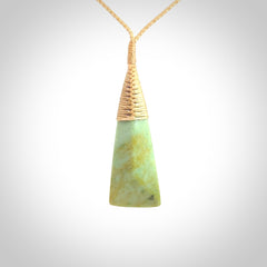 This photo shows a medium sized jade drop shaped pendant. It a a lovely varied green and light orange New Zealand Flower jade. The cord is a four plait beige and is adjustable in length.